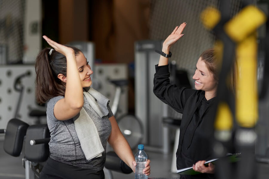 two women high fiving in a gym