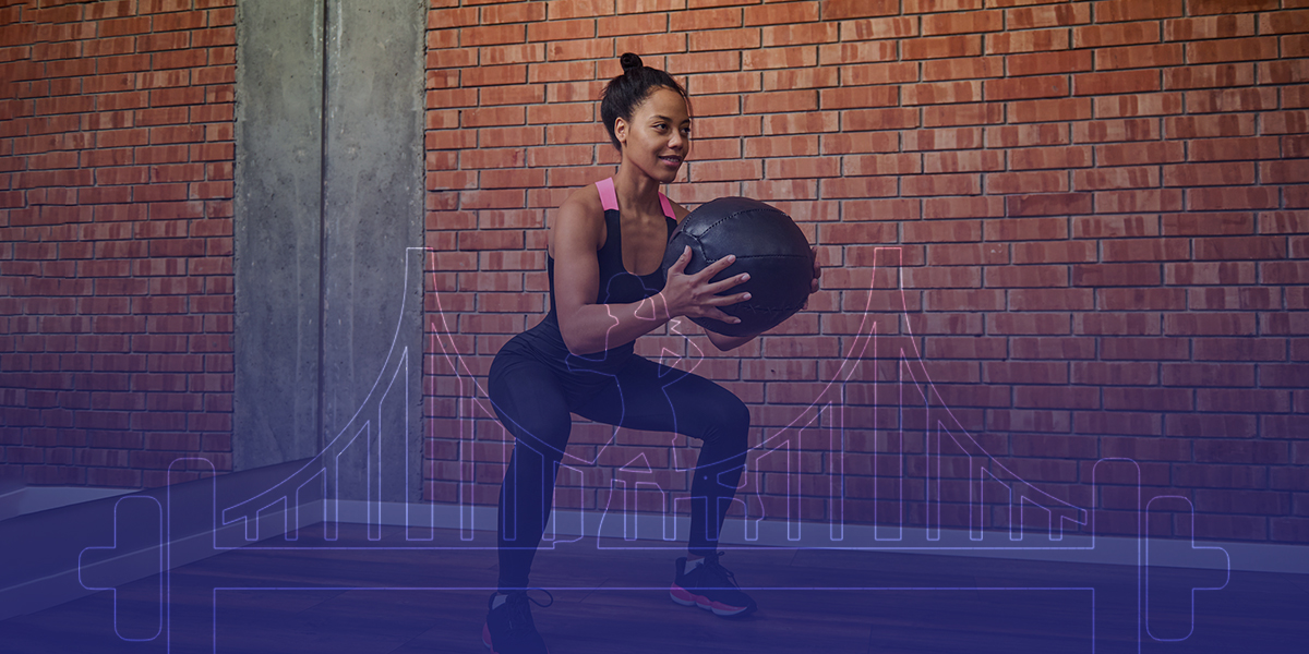 woman doing squats with a medicine ball