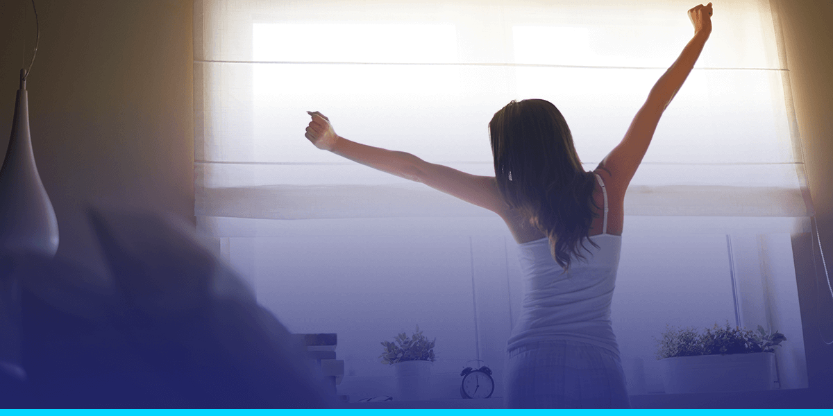 a woman stretching her arms in front of a window
